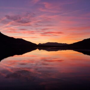 reflet d'un coucher de soleil rosé sur le lac de Serre-Ponçon